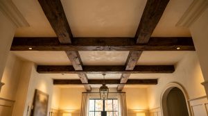 Living room ceiling featuring dark exposed wooden beams and a brass pendant light