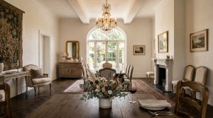 Elegant formal dining room featuring a crystal chandelier, herringbone wood floors, and a traditional fireplace.