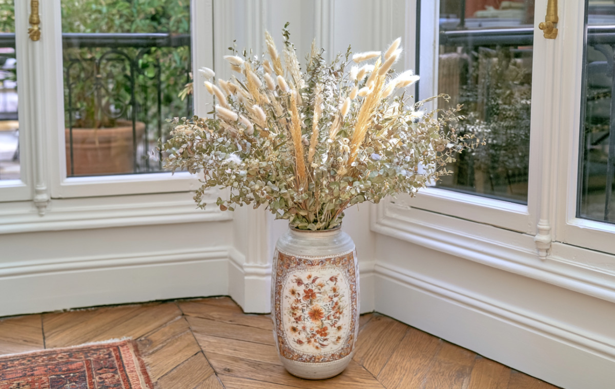 Vintage ceramic floor vase filled with a tall dried floral arrangement featuring pampas grass and eucalyptus.