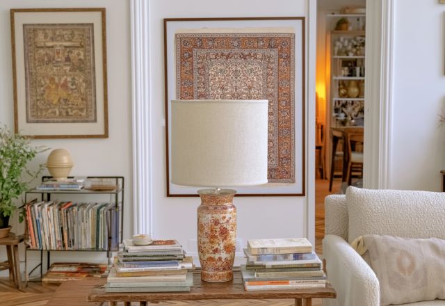 Eclectic living room lighting featuring a floral ceramic table lamp and wall hanging on white plaster walls.