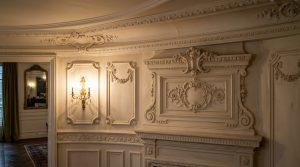 Detailed French wall moldings and boiserie panels in a historic sitting room.