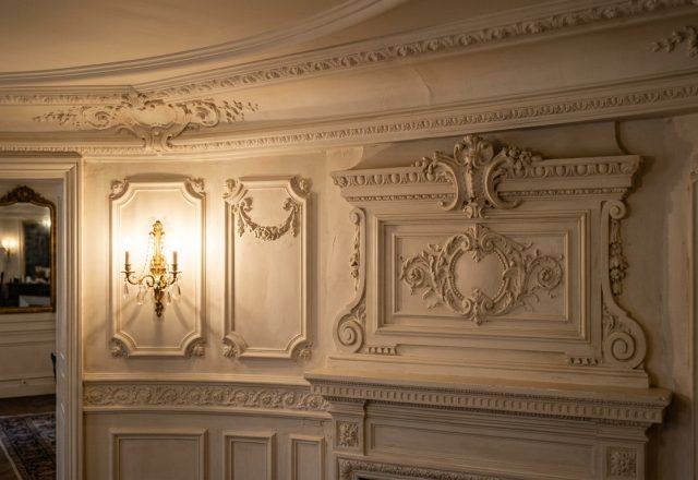 Detailed French wall moldings and boiserie panels in a historic sitting room.