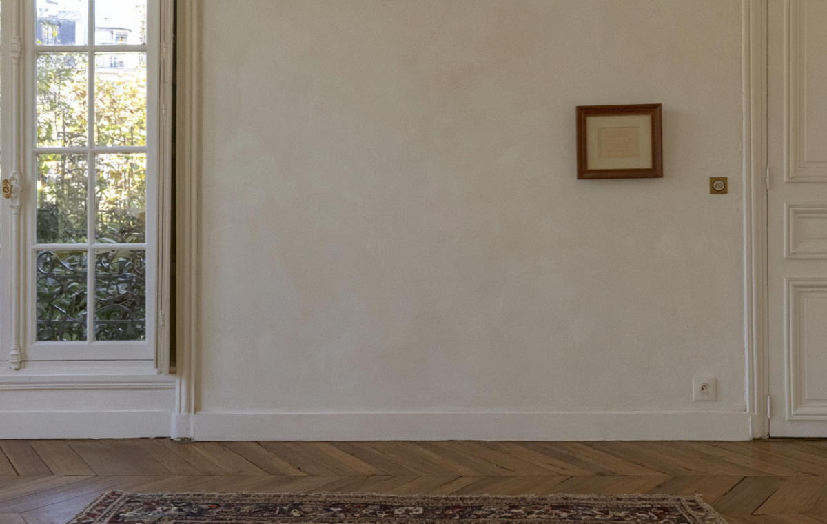 Hardwood flooring maintenance in a bright room with classic parquet and tall windows showing natural daylight reflection.