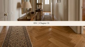 Classic herringbone wood flooring and runner rug in a bright, elegant hallway.