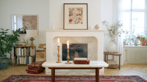 Historical fireplace decor featuring an antique mantel, botanical art, and wooden candle holders in a bright living room