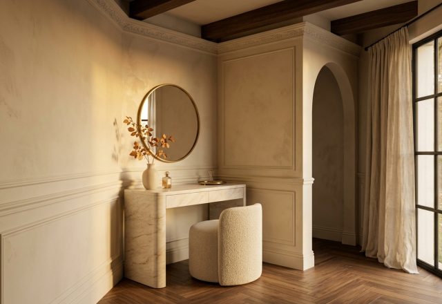 A sophisticated vanity table setup featuring a curved marble desk, boucle stool, and round brass mirror in a neutral room.