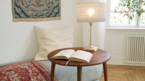 Cozy reading nook lighting featuring a fabric table lamp and open book on a wooden table