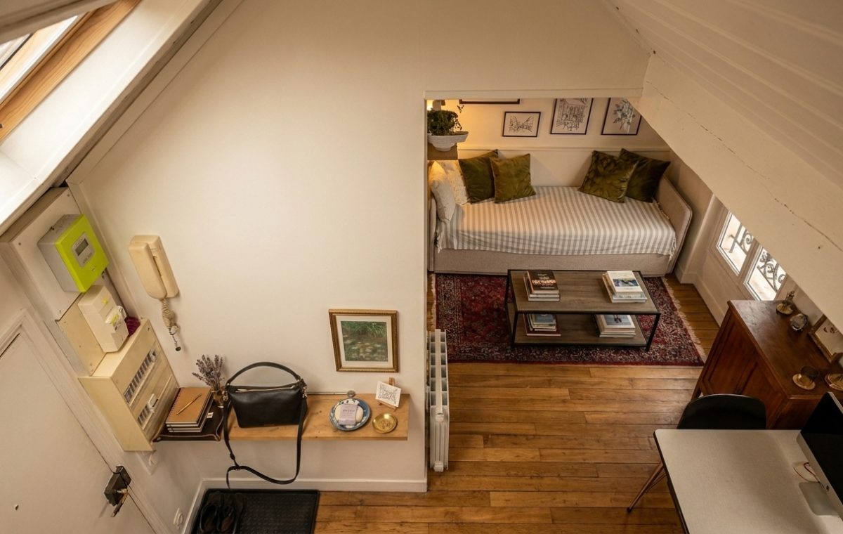 Cozy loft living room featuring a daybed under sloped ceilings and wooden flooring