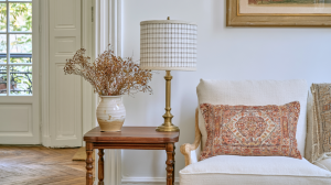 Accent lighting styling featuring a brass table lamp and wooden side table next to a neutral armchair