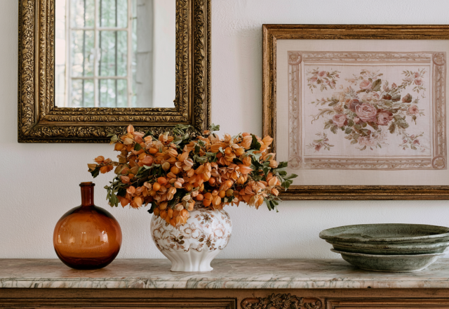 Antique sideboard styling with marble top, framed floral art, vintage mirror, and dried botanical arrangement