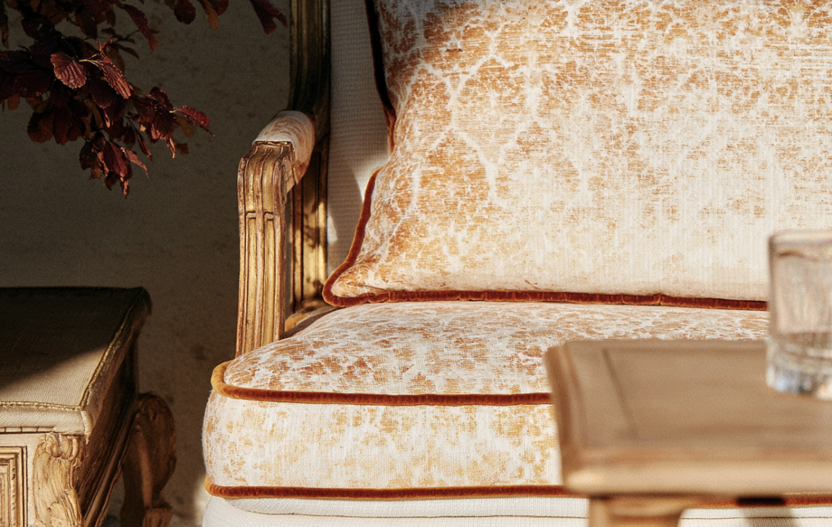 Vintage armchair styling with distressed gold upholstery and classic wooden side table.