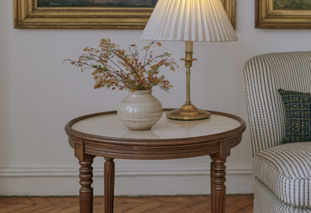 Vintage side table styling with a brass lamp and ceramic vase in a traditional living room