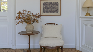 Neutral corner styling featuring an antique wooden table, dried botanicals, and a linen accent chair.