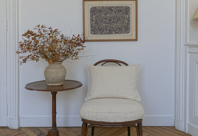 Neutral corner styling featuring an antique wooden table, dried botanicals, and a linen accent chair.