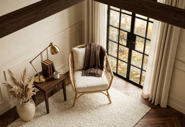 Neutral living room styling featuring a cozy armchair, brass lamp, and textured rug near French doors.
