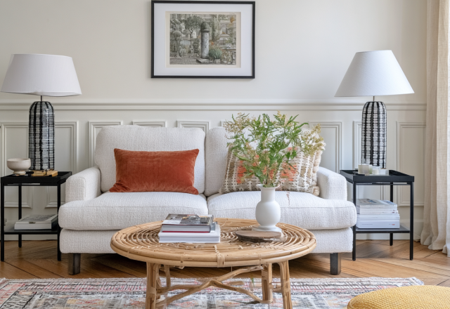 Bright transitional neutral living room styling featuring a white boucle sofa, rust lumbar pillow, and matching statement lamps.