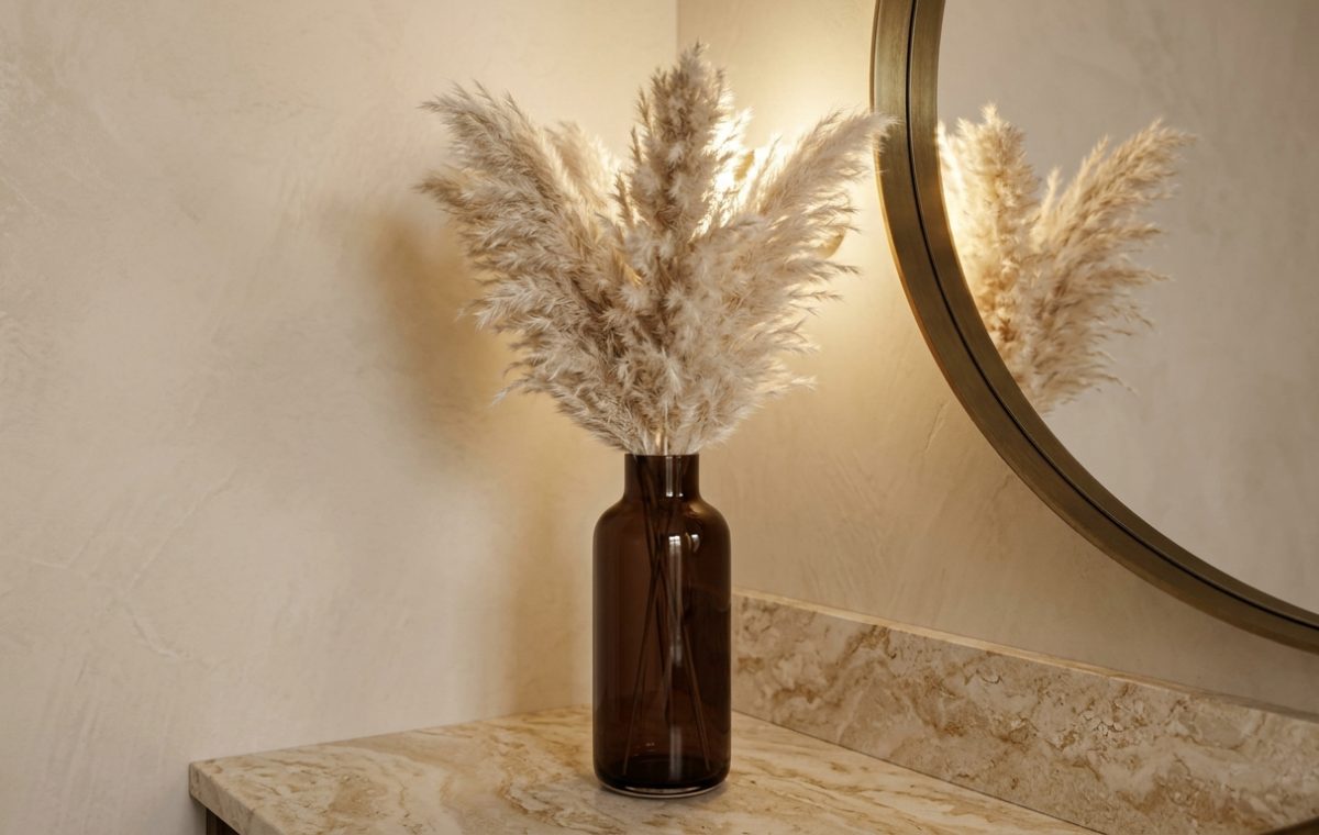 Powder room decor ideas featuring pampas grass in an amber glass vase on a marble vanity