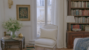 Cozy reading room interior design featuring built-in bookshelves, a white linen chair, and a large window.