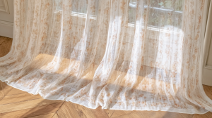 Sheer linen curtains with botanical prints pooling gracefully on herringbone hardwood floors.
