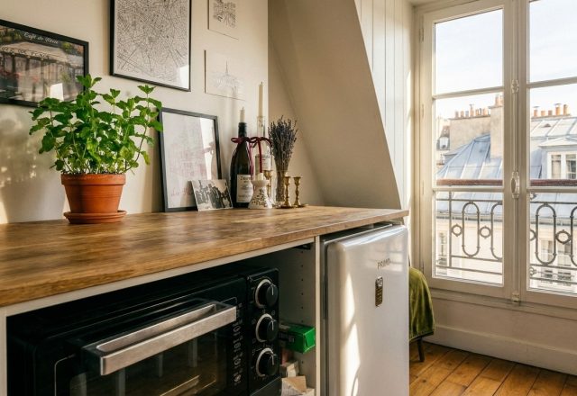A bright small kitchenette design featuring wood countertops, white mini fridge, and fresh herbs.