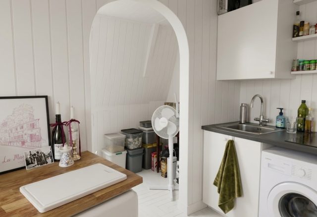 Compact small laundry room layout featuring a washer next to a kitchen sink under floating shelves