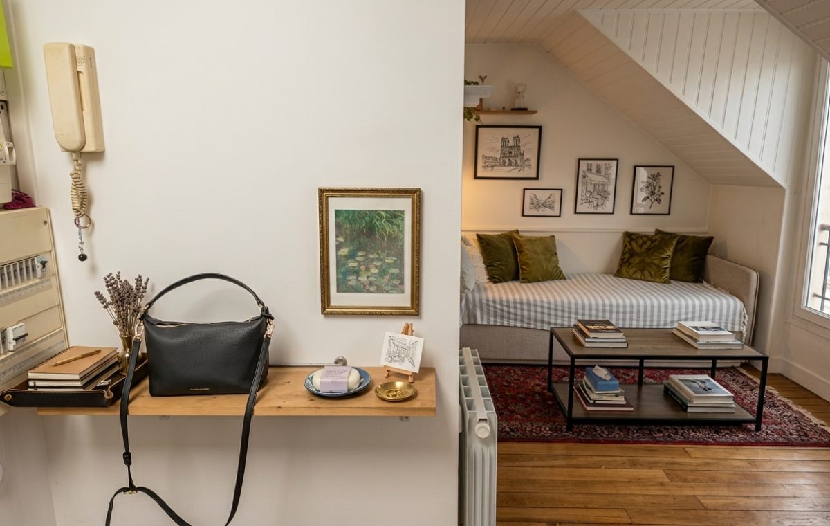 Small studio apartment organization featuring a floating entryway shelf and cozy attic living space