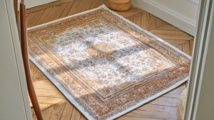 A vintage style area rug placed on herringbone hardwood floors next to white baseboards.