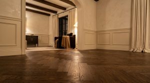 Close up of herringbone wood flooring in a luxury transitional living room with wainscoting.