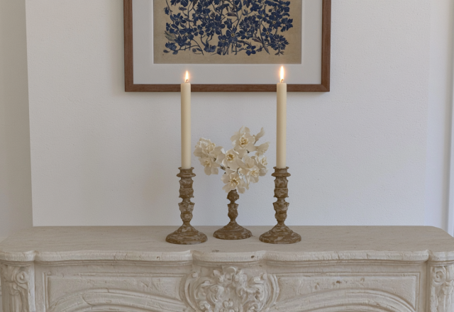Elegant mantel decor ideas featuring lit taper candles and white flowers on a vintage stone fireplace