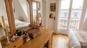 Wooden dressing table decor with vintage mirror and perfume bottles in an attic bedroom