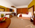 Stylish Auris Plaza Hotel with The Modern Interior Design Gallery: Amazing bedroom decorating idea with wooden furniture and modern box pattern rug