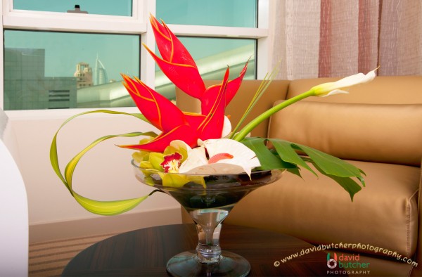Flower in vase decoration for single round wooden table in auris plaza hotel