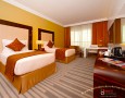 Stylish Auris Plaza Hotel with The Modern Interior Design Gallery: Yellow and gold bedroom theme combined with red cushion and bedding